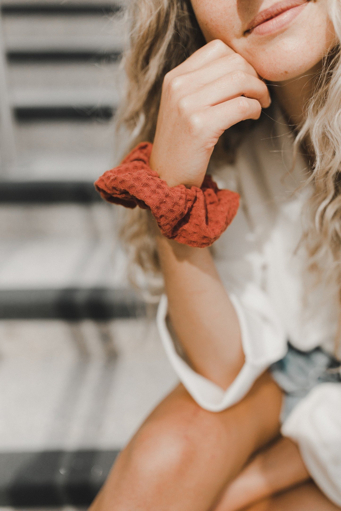 woman with burnt orange scrunchie on wrist