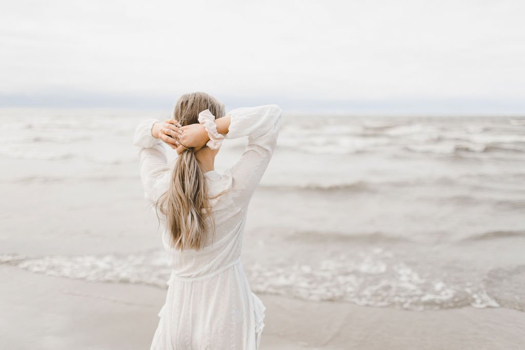 tying up hair with a scrunchie, at a beach