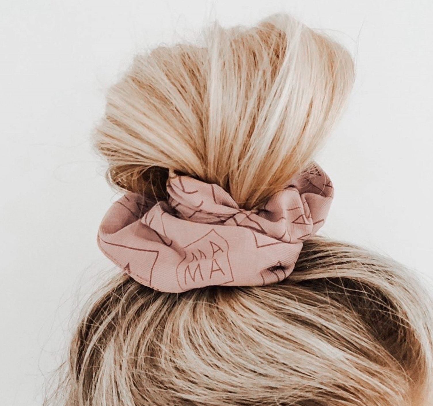 woman with topknot and MAMA scrunchie in her hair